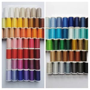 May include: A collection of 100 spools of thread in various colors, arranged in rows. The spools are labeled "Isabelle Haberdashery".