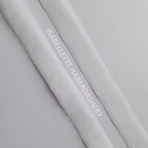 May include: Two white fabric trims, one with a fuzzy texture and the other smooth, with the text "ISABELLETTE HABERDASHERY" printed on the smooth trim.