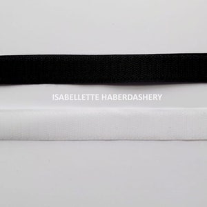 May include: Black and white hook and loop tape, also known as Velcro.  The tape is shown on a white background.  ISABELLETTE HABERDASHERY is printed below the tape.