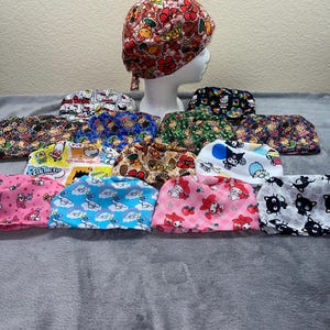 May include: A collection of 15 colorful surgical caps with various cartoon character designs, including Hello Kitty, My Melody, and Tuxedo Sam. The caps are made of soft, breathable fabric and are perfect for nurses, doctors, and other healthcare professionals.