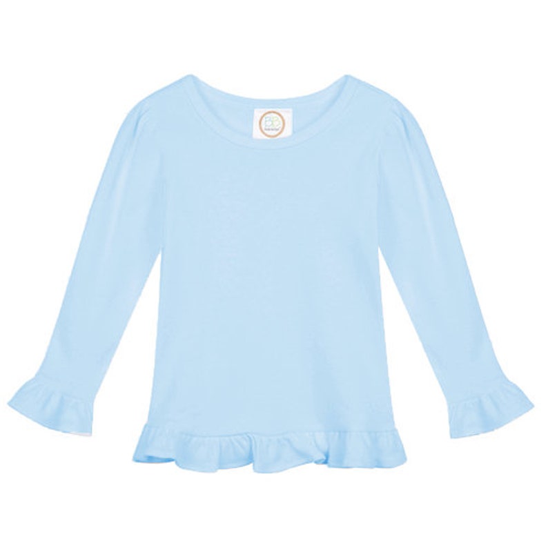 May include: A light blue long-sleeved shirt with a ruffled hem and ruffled cuffs. The shirt has a round neckline and a small white tag with the text "PB & J" on the front.