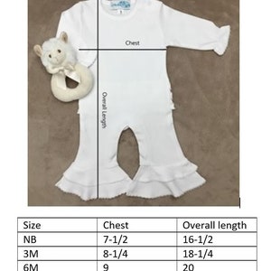 May include: A white baby onesie with ruffled legs and long sleeves. The onesie is laid flat and measured for size. The measurements are listed in a table below the onesie. The table shows the size, chest measurement in inches, and overall length in inches.