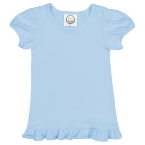 May include: A light blue short-sleeved t-shirt with a ruffled hem. The shirt has a round neckline and a small tag with the text "BB Boutique" on the front.