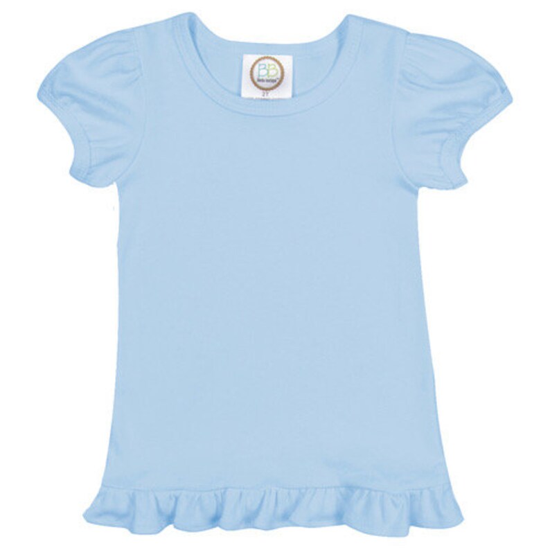 May include: A light blue short-sleeved t-shirt with a ruffled hem. The shirt has a round neckline and a small tag with the text "BB Boutique" on the front.