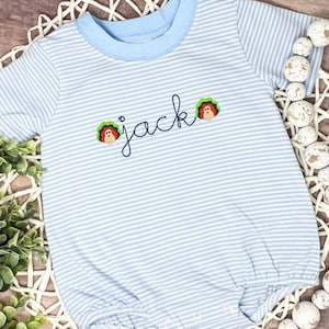 May include: A light blue and white striped baby onesie with the name "jack" embroidered on the front. Two small embroidered turkeys are on either side of the name.