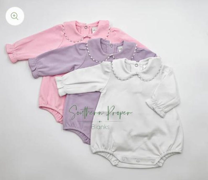 Pu&ograve; includere: Tre body per neonati con colletti a volant. I body sono rosa, lavanda e bianco. I body hanno maniche lunghe e chiusure a pressione.