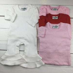 May include: Four baby onesies, one white with ruffled trim, one pink with white stripes, one red, and one pink with a bow. All onesies have a small tag with the text "Little Buns" on them.