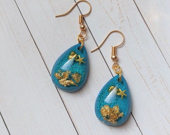 Ocean resin earrings, w/ gold flake accent - gold starfish/clam combo and blue alcohol ink background
