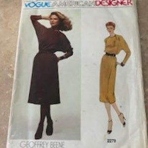 May include: Vintage Vogue pattern for a dress by Geoffrey Beene. The pattern shows two models wearing a brown and a yellow dress with a long sleeve and a belt.