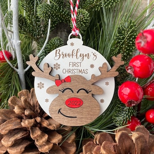 May include: A wooden Christmas bauble shaped like a reindeer with a red bow and the text "Brooklyn's First Christmas 2022".