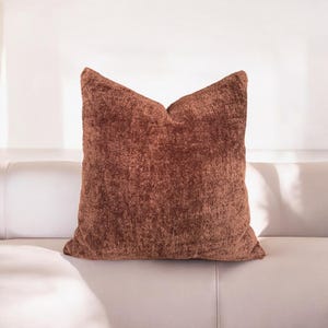 Peut inclure: Un coussin de canap&eacute; brun et moelleux avec une surface textur&eacute;e douce.