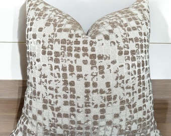 May include: A decorative throw pillow with a geometric pattern in shades of brown and white.