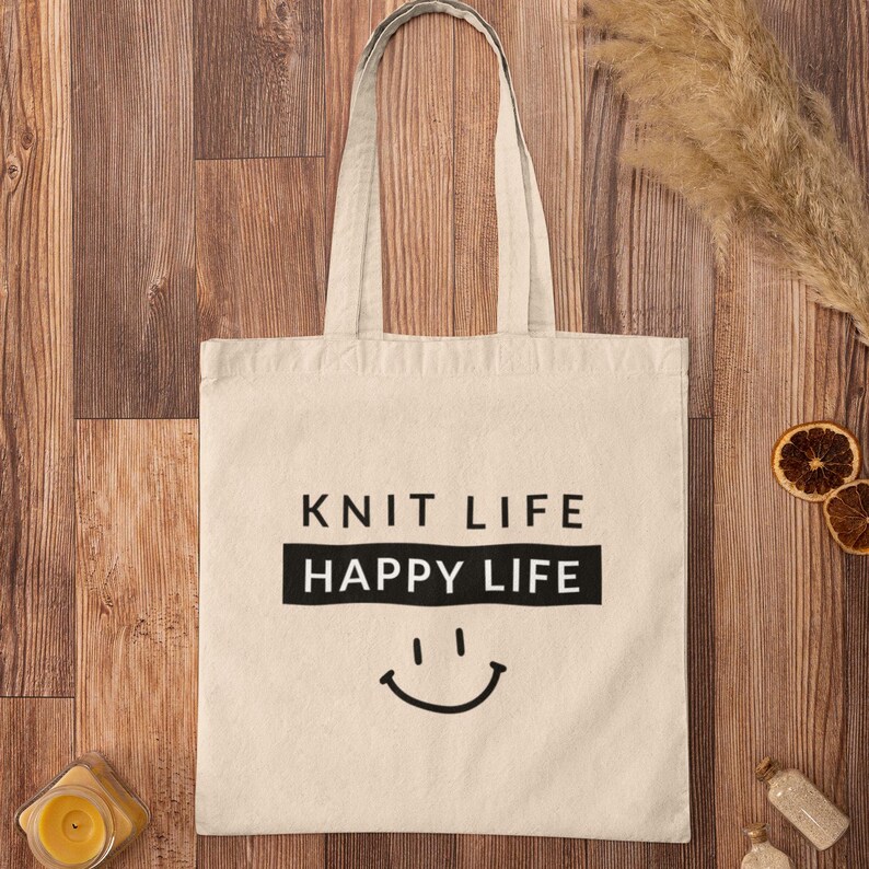 Tote bag on wood floor that says "Knit Life Happy Life"