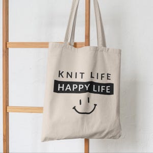 Tote bag hanging on decor.  Bag says "Knit Life Happy Life"