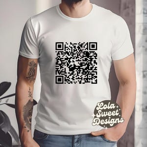 Peut inclure: T-shirt blanc avec un motif de code QR noir. Le texte "Lola Sweet Designs" est imprimé dans le coin inférieur droit du t-shirt.