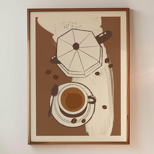 May include: A framed art print featuring a coffee-themed illustration. The artwork depicts a coffee cup, coffee beans, and a stovetop espresso maker in shades of brown and beige. The print is displayed on a white wall in a kitchen setting.
