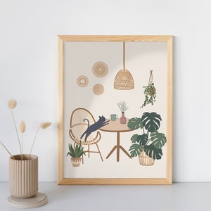 May include: A framed art print featuring a whimsical interior scene. A black cat leaps over a table set with a mug and vase. The scene includes a woven chair, hanging plants, and a woven pendant light. The color palette is neutral with green and brown accents.