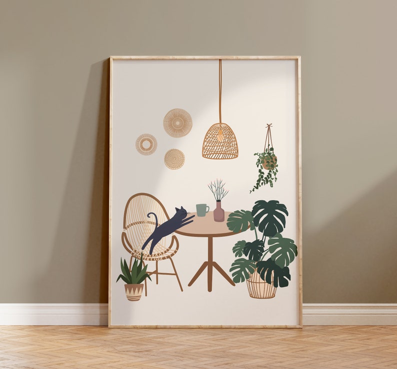 May include: A framed art print featuring a minimalist interior scene. The illustration depicts a cat leaping over a chair, a round table, and potted plants. The color palette includes beige, brown, green, and black. A woven pendant light and wall decor add to the bohemian aesthetic.