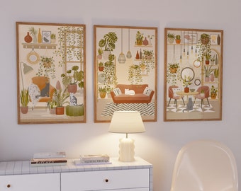 May include: Three framed art prints depicting cozy interior scenes with cats and lush plants. The artwork features warm color palettes, including shades of brown, green, and beige. Each print showcases a different room setting with furniture and decorative elements.