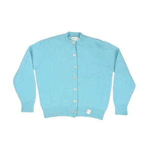 May include: A light blue cardigan sweater with long sleeves and a round neckline. The sweater has a button-up front with six buttons and a small tag near the bottom. The knitwear is a solid, soft blue color.