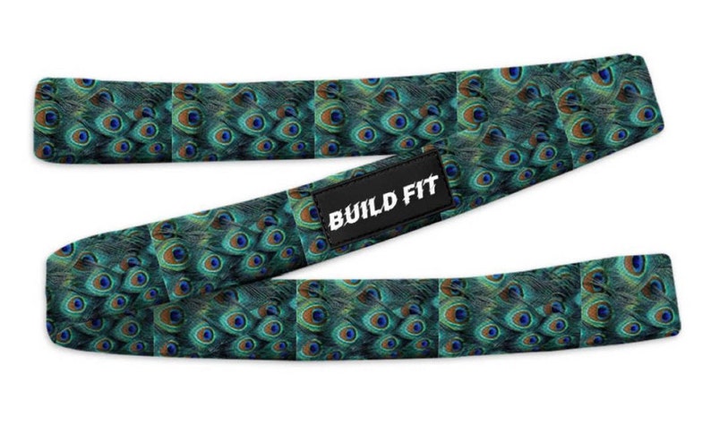 May include: A green and blue exercise resistance band with a peacock feather pattern. The band has the text "BUILD FIT" printed on it.