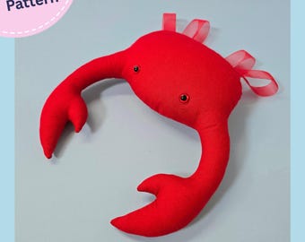 May include: A bright red fabric crab-shaped headpiece featuring two dark eyes and two large claws. The top of the crab is adorned with several translucent red ribbon loops. The text "PDF Pattern" is visible in the upper left corner.