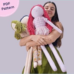 Puede incluir: Tres muñecas de tela hechas a mano con pelo de lana. Una muñeca tiene pelo rosa brillante, una blusa de cuadros vichy rosa y blanco y una falda rosa claro. Otra muñeca tiene pelo verde oliva y un conjunto floral. La tercera muñeca tiene pelo azul oscuro.