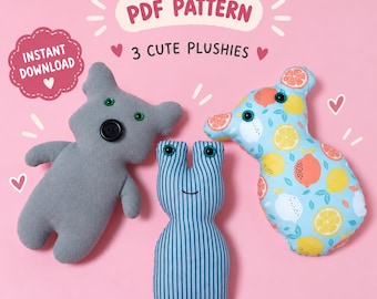 May include: A PDF pattern for 3 cute plushies featuring text that reads PDF PATTERN, 3 CUTE PLUSHIES, and INSTANT DOWNLOAD. The plushies include a solid gray koala-shaped toy with button eyes, a blue striped vertical toy, and a citrus fruit print toy.