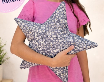 May include: A star-shaped pillow featuring a blue fabric with a white daisy floral pattern. The item is labeled as a PDF Pattern in the upper left corner. The pillow has five points and is constructed from a printed textile material.
