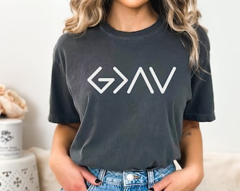 May include: A dark grey t-shirt with a white graphic of the word "God" written in a stylised font.