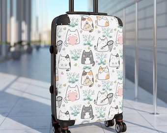 May include: A white suitcase with a black handle and wheels. The suitcase has a pattern of cartoon cats holding hearts and fishing nets.