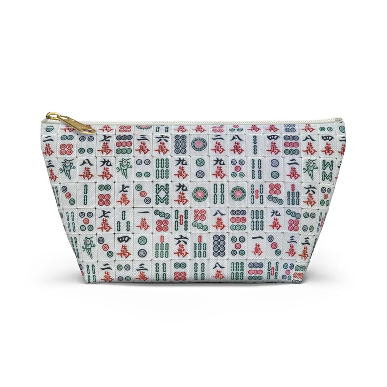 May include: White zippered makeup bag with a pattern of Chinese mahjong tiles in red, green, and black.