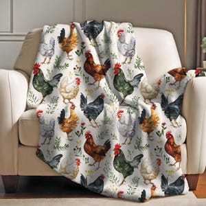May include: A white throw blanket with a repeating pattern of colorful chickens and green foliage. The chickens are in various poses, including standing, walking, and pecking.