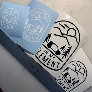 May include: Three different versions of a sticker design featuring a black and white silhouette of a car in a mountain landscape with the text "In My Element".