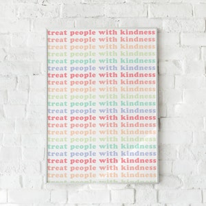 May include: A white framed print with the text "treat people with kindness" repeated in a rainbow of pastel colors.