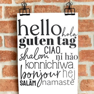 May include: A white poster with black text that says "hello hola guten tag shalom CIAO ni hao konnichiwa bonjour hej SALAM namaste" hanging on a brick wall.