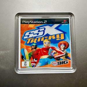 Può includere: Una custodia per videogiochi PlayStation 2 con uno sfondo arancione, blu e giallo brillante. Il gioco si chiama "SSX Tricky" e presenta una donna con un abbigliamento rosso e blu che fa snowboard. Il gioco è classificato G per tutti i pubblici.