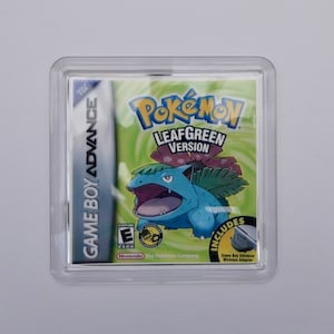 May include: A clear plastic case with a green, yellow, and blue Game Boy Advance video game cartridge inside. The game cartridge is for the Pokemon LeafGreen Version. The game cartridge has a picture of a blue and green Pokemon character on it. The text "Pokemon LeafGreen Version" is printed on the cartridge.