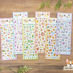 May include: Six vertical sheets of stickers labeled Cutie Happy, featuring various colorful designs including hamsters, rabbits, dogs, monkeys, bears, and pandas, along with small icons like rainbows, apples, musical notes, and stars on clear backing.