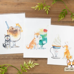 Puede incluir: Tres impresiones en acuarela con perros Shiba Inu con bebidas y postres. Una impresión muestra un perro con café helado, otra con refresco verde y la última con un helado de crema blanda.