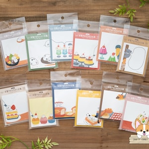 Può includere: Un set di 12 note adesive colorate con simpatiche illustrazioni di dolci e animali. Ogni nota ha il testo "Kawaii Sticky Notes" in giapponese.