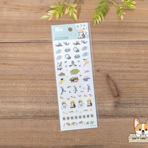 Op de afbeelding: Een vel stickers met illustraties van personages uit de animefilm "Howls bewegende kasteel". De stickers zijn op een witte achtergrond met blauwe randen. De tekst "Schedule Seal" staat bovenaan het vel gedrukt.