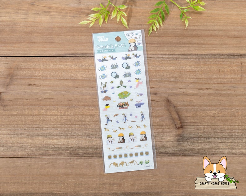 Op de afbeelding: Een vel stickers met illustraties van personages uit de animefilm "Howls bewegende kasteel". De stickers zijn op een witte achtergrond met blauwe randen. De tekst "Schedule Seal" staat bovenaan het vel gedrukt.