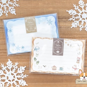 May include: Two blank note cards with winter themes. The top card is blue with snowflakes and the text "Winter Letters & Envelopes". The bottom card is cream with a winter scene and the text "Winter Letters & Envelopes".