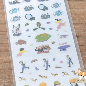 Op de afbeelding: Een vel met transparante stickers met personages en objecten uit de animatiefilm 'Het Kasteel in de Lucht'. De stickers bevatten een meisje met rood haar, een jongen met bruin haar, een vliegtuig, een kasteel en andere fantasierijke ontwerpen.