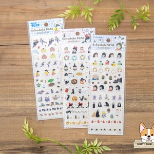 May include: Three sticker sheets with various cartoon illustrations. Each sheet is labeled "Schedule SEAL" and features different characters and objects. The stickers are in clear packaging, and the background is a wooden surface with green leaves.