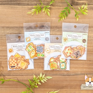 May include: Four packs of washi tape featuring illustrated toast designs. Each pack has the text "Washi Flake Seal Love Toast" and "30 Pieces".
