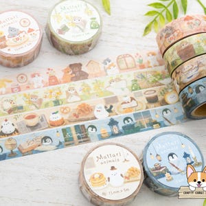 May include: Decorative washi tape rolls featuring animal illustrations. The rolls display various designs with cats, penguins, and other creatures. Each roll is 15mm x 5m. The tape is ideal for scrapbooking, journaling, and crafting projects.