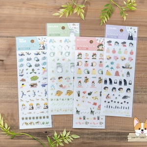 Op de afbeelding: Vier vellen met kleurrijke stickers met personages uit de animatiefilm 'Het bewegende kasteel van Howl'. Elk vel heeft een andere achtergrondkleur en bevat verschillende personages en objecten uit de film. De stickers zijn gelabeld met 'Schedule Seal'.