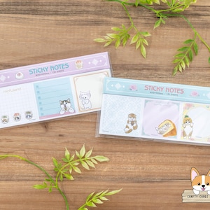 May include: Two packs of sticky notes featuring adorable animal illustrations. The top pack has a light blue background with white and pink accents. The bottom pack has a light blue background with white and light green accents. Both packs have the text "Sticky Notes" printed on them.